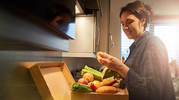 Woman unpacking meal kit box