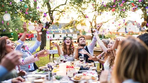 Wedding party celebrates al fresco at a summer garden reception.